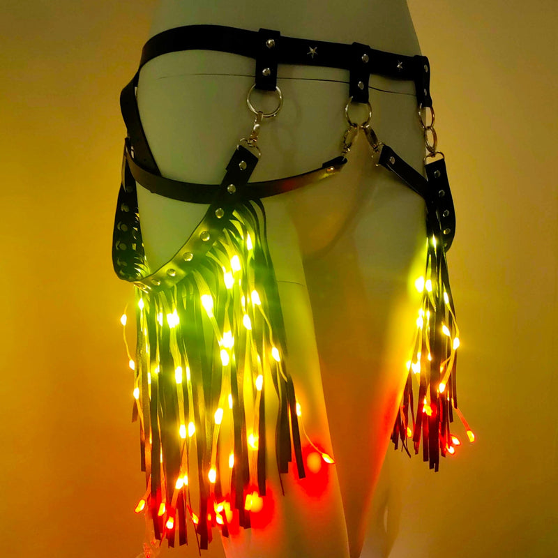 Black leather LED fringe garter belt on a mannequin glowing green, yellow and red, a light up garter and rainbow gradient thigh accessory for go-go dancers, burlesque performers and drag stagewear, perfect for music festivals, Halloween costumes, Pride parades and New Year's Eve parties, Neon Cowboys