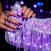 Close-up of hands holding a silver LED fringe purse glowing purple at a party, a glowing light up purse and light up fanny pack alternative perfect for raves, EDM concerts, festivals and Pride nights out, Neon Cowboys