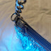 Close-up of a silver LED fringe purse zipper and chain strap glowing blue, a glowing light up purse and star-purse style bag perfect for raves, EDM concerts, festivals and nights out, Neon Cowboys