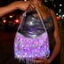 Woman on a city street at night holding a silver LED fringe purse glowing purple, a glowing light up purse and star-purse style bag perfect for raves, concerts, music festivals and disco cowgirl nights out, Neon Cowboys