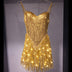 LED Fringe Sequin Dress by Neon Cowboys, a gold light up sequin fringe dress with the fringe glowing warm gold on a hanger, this led fringe sequin dress, led dress and light up dress with a led bodysuit base is space cowgirl and showgirl, go-go dancer and drag stagewear for raves, EDM concerts, festivals and bachelorette parties, Neon Cowboys