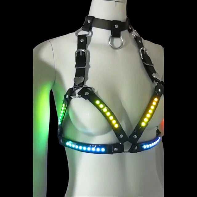 LED Halter Harness lit up in green, yellow and blue — a made-to-order color-changing halter harness bra with choker collar and heart hardware, for rave, burlesque and stage.