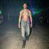 LED Harness by Neon Cowboys, a shirtless man in a green and purple glowing light up harness walking through laser beams at a warehouse rave, this neon harness and led harness for men is bold rave performer and go-go dancer stagewear for festivals, EDM concerts, EDC, Pride and club nights, Neon Cowboys