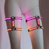 Mannequin legs in a two-piece LED leg harness set glowing pink and orange up close, a Neon Cowboys color-changing light up couture leg harness and led harness set, go-go and burlesque stagewear for raves, EDC and Pride, Neon Cowboys