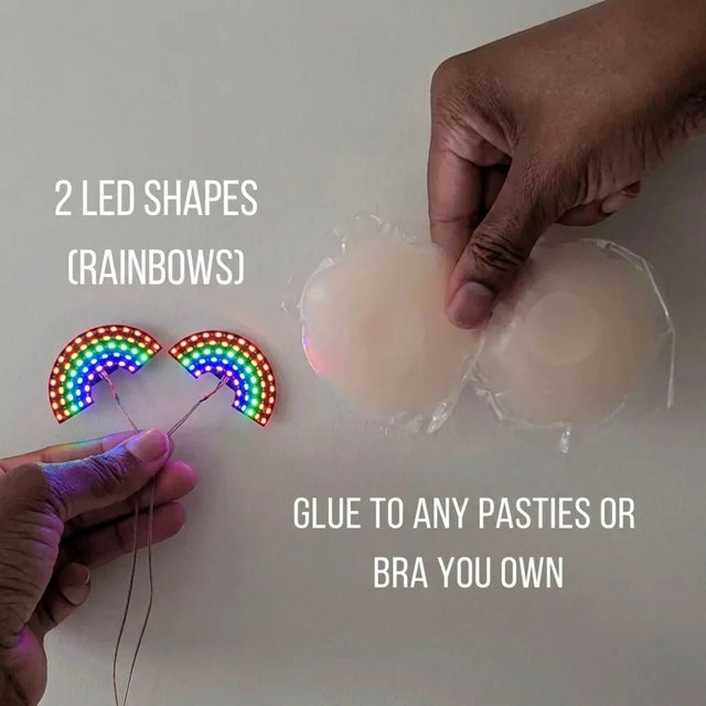 Two glowing rainbow LED shapes next to silicone pasties — light-up rainbow nipple covers you glue onto any pasties or bra