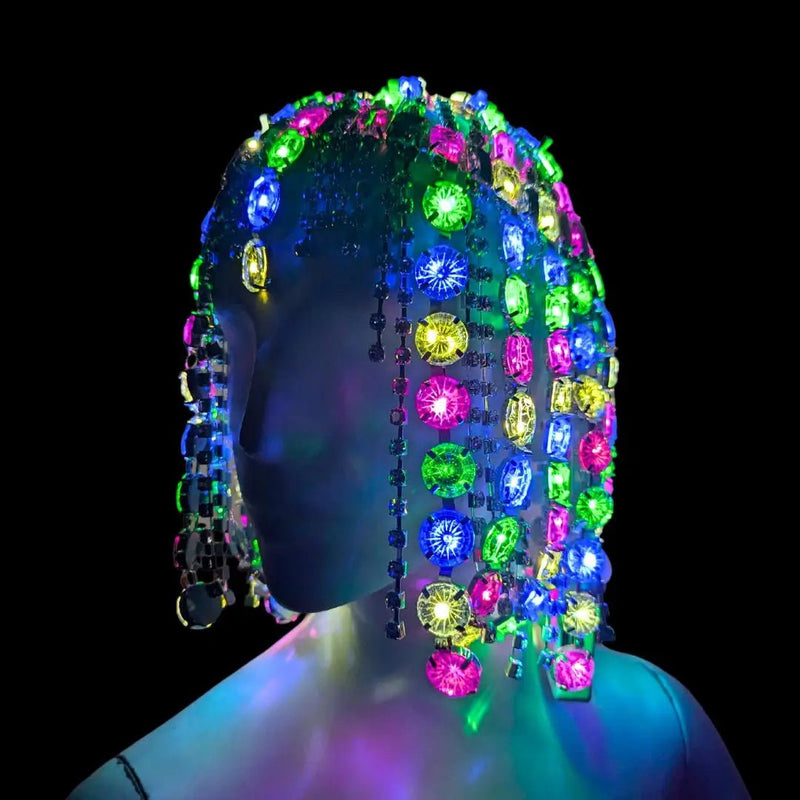 Neon Cowboys multicolor LED Rhinestone Gem Head Piece draping over a mannequin with crystal strands glowing rainbow, crystal-encrusted illuminated light up headwear for showgirls and festival performers, raves, EDM festivals and Cleopatra-inspired looks, Neon Cowboys