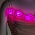 A close-up of the LED light up roses glowing pink along the neckline of the blush rose corset, a light up corset and LED rose corset stagewear for go-go dancers, burlesque performers and festival dancers at raves, music festivals, and Coachella, Neon Cowboys LED rose corset, Neon Cowboys
