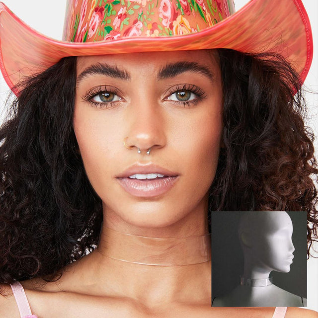 Woman with curly hair wearing pink cowboy hat and light up WANTED choker for country western themed bachelorette party outfit that combines festival fashion with fun glowing accessories