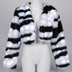 Woman dancing at a festival in a white glowing zebra LED faux fur crop jacket with silver shorts and boots, a color-changing light up coat and led costume for festival dancers and showgirl stagewear at raves, Coachella and Pride, Neon Cowboys