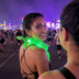 Woman smiling at a night festival wearing a green glowing LED light-up bandana, neon bandana and led bandana glow accessory for a rave, music festival or St Patricks Day, Neon Cowboys rave bandana