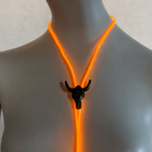 Orange glowing bolo tie on neutral background demonstrating bright illumination effect for western themed nightlife events and rodeo after parties, texas tailgating football games