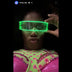 Performer in a pink rhinestone outfit wearing green glowing LED cyber glasses at night, futuristic light up glasses and space glasses for raves, music festivals, EDM concerts, drag shows, and stage performances, Neon Cowboys