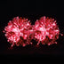 Glowing red LED light-up pom poms lit up in the dark — a rechargeable, remote-controlled color-changing pair of cheerleading pom poms for game day, dance and raves.