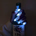 Model in white lifting her hand of blue glowing LED light-up press-on nails to her waist, wireless led nails and light up nails that glow for a rave, EDM concert or wedding, Neon Cowboys