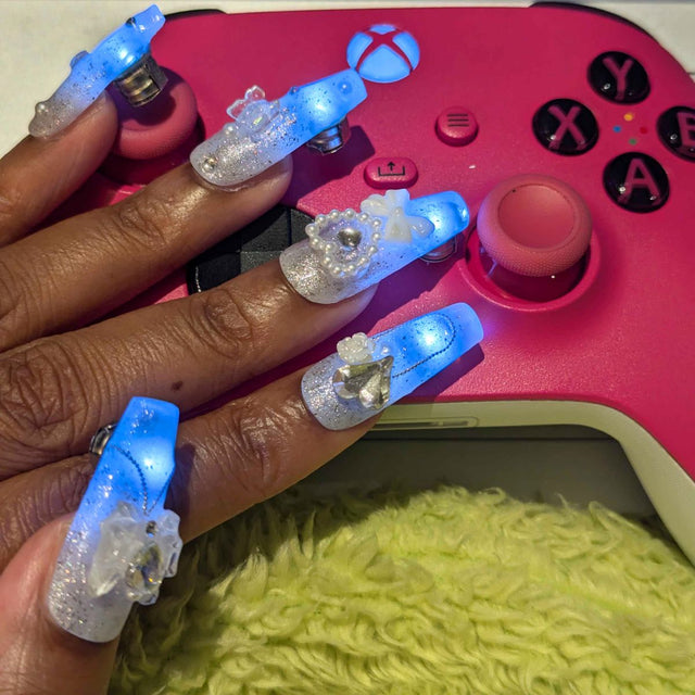 Woman in a white fringe jacket framing her face with glowing LED light-up press-on nails, wireless led nails and light up nails accessory for a rave, music festival or disco cowgirl look, Neon Cowboys