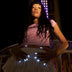 Woman holding a white glowing LED light-up skirt hem lighting her nails at a night fair, wireless led nails and light up nails accessory for a rave, music festival or Coachella, Neon Cowboys