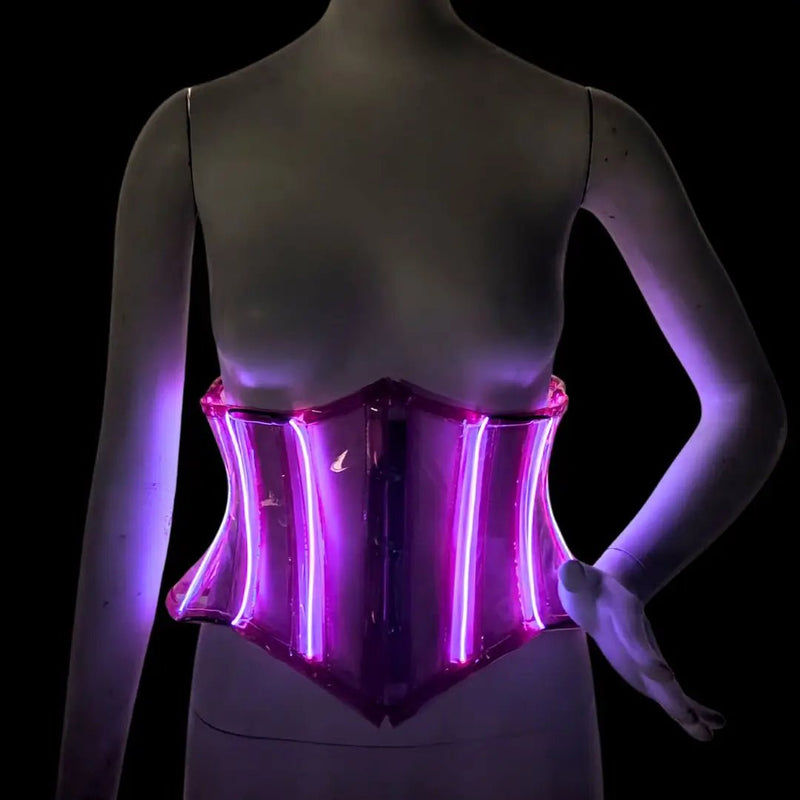 A pink transparent LED PVC corset glowing on a mannequin against a black background, a glowing light up corset and led corset cincher with a flattering fit, glowing stagewear and a performance outfit for go-go dancers, burlesque performers and drag at raves, festivals and nightclub fashion, Neon Cowboys