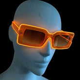 Orange glowing LED light up square party sunglasses shown on a mannequin head against a black background, illuminated futuristic party glasses and festival sunglasses for raves, EDC, and Halloween costumes, Neon Cowboys
