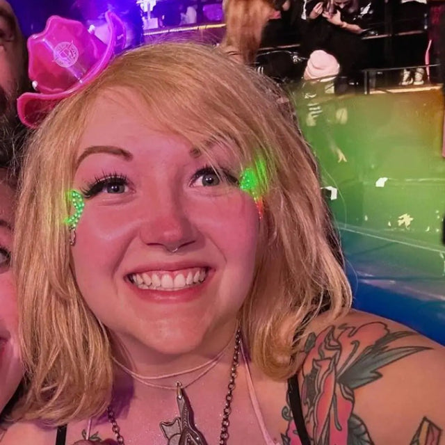 Concert-goer enhancing festival experience with mini neon cowboys hat for country music tours state fairs and outdoor summer entertainment events
