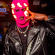 Person in leather jacket wearing pink LED balaclava - Cyberpunk illuminated mask for underground clubs, DJ performances, fashion-forward streetwear, and viral content creation