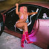 Woman in pink car wearing illuminated transparent boots showing stylish festival fashion for Instagram worthy photos and social media content