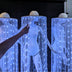 Performer in a Neon Cowboys Remote Controlled LED Fringe Cowboy Hat with floor-length glowing blue fiber-optic fringe on a dark stage — light-up stagewear for touring dancers, drag performers and event entertainers