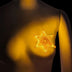 Yellow LED sheriff badge on chest in dark setting - Illuminated 3D printed police accessory for Woody costumes, space cowgirl outfits, western-themed parties, and Halloween events