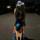 Woman and dog wearing matching blue LED cowboy hats at night - Illuminated owner and pet western headwear for evening walks, pet-friendly festivals, and outdoor adventures