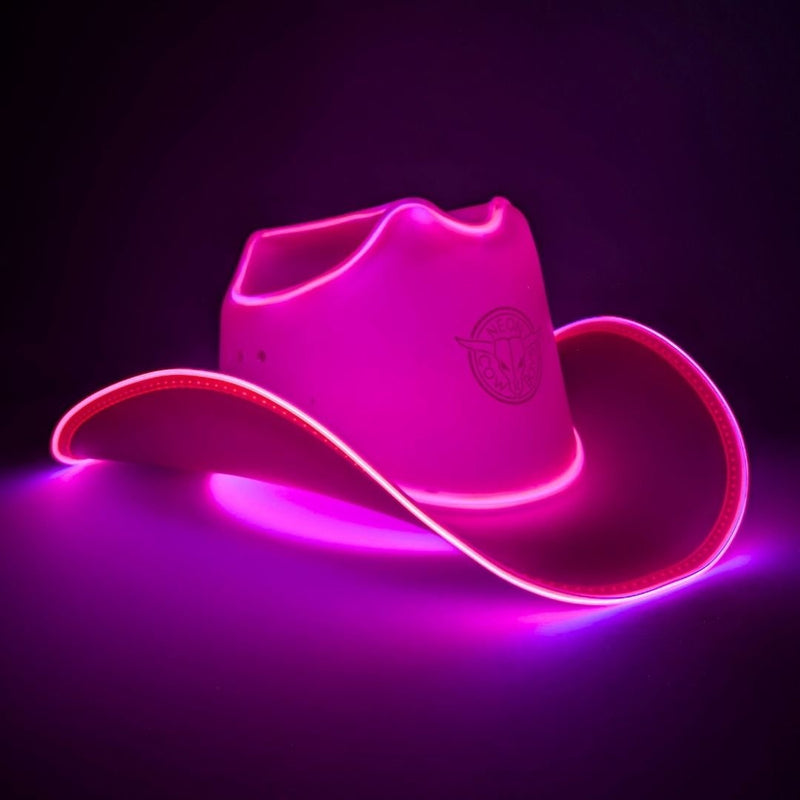 Pink glowing LED light-up cowboy hat with illuminated brim edge on a dark studio background, hot pink space cowgirl LED hat lifestyle product shot, light up cowboy hat, neon cowboy hat, great for space cowgirl costume parties neon accessories sci-fi themed events cosmic Halloween outfits, Neon Cowboys
