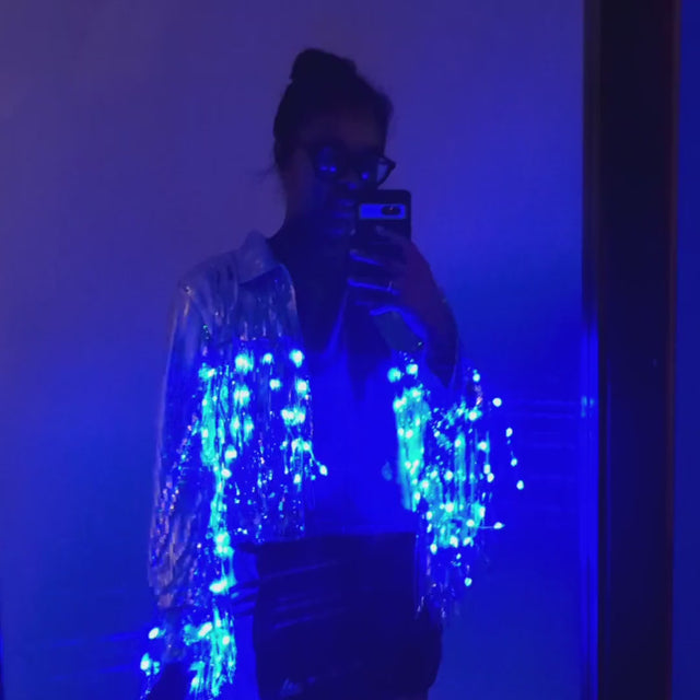 Person wearing blue LED sequin fringe jacket in dark setting video - Color-changing sequin apparel demonstration showing movement and light patterns for dance performances and stage appearances