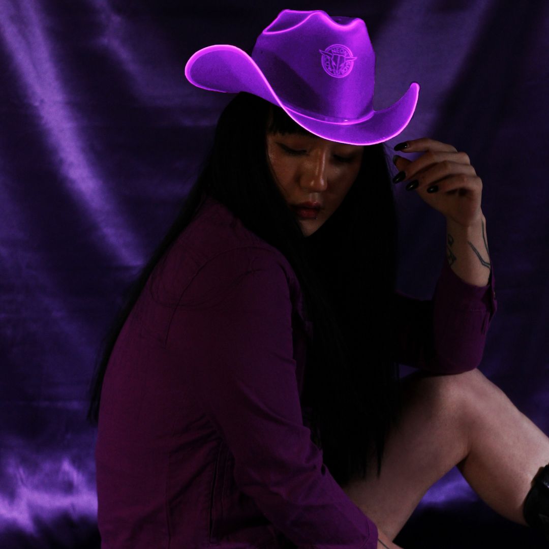 Purple neon cowboy hat with bright LED lights perfect for lavender aesthetic photoshoots Instagram styling and western fashion