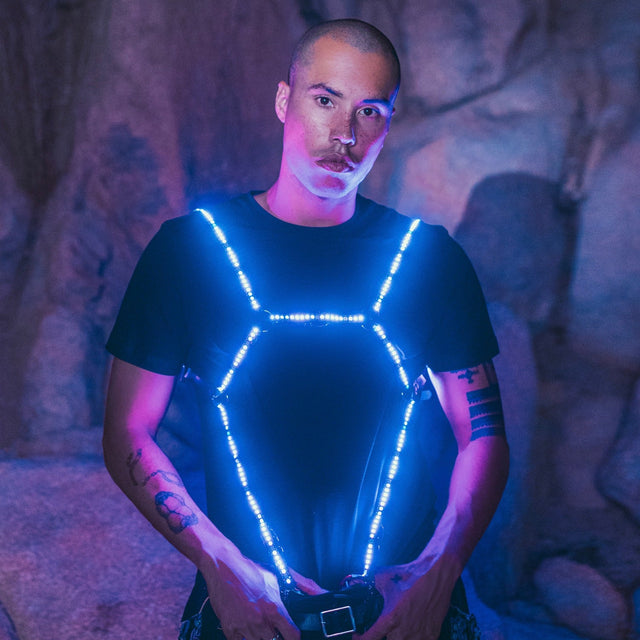Male wearing geometric blue LED harness against dark background showcasing vibrant illumination perfect for EDM concerts theatrical performances and LGBTQIA+ night life events
