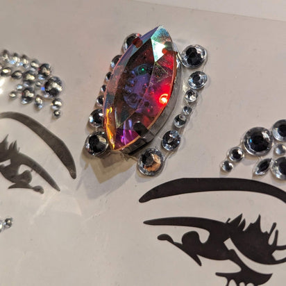 Close-up of colorful LED rhinestone face gem applied on face - Vibrant color-changing gemstone facial accessory for Halloween costumes, cosplay events, Burning Man outfits, and futuristic character designs