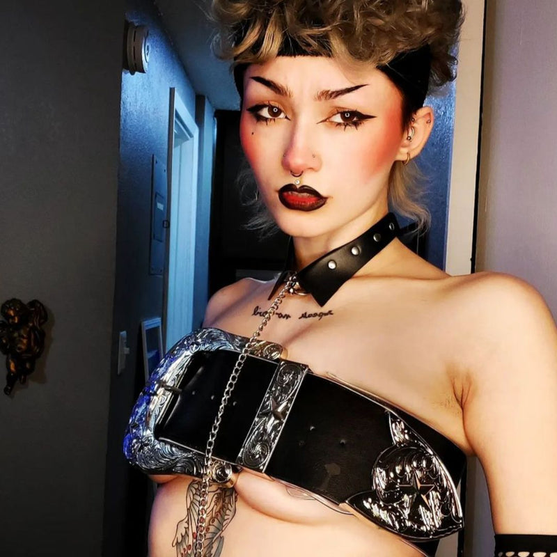 Person wears the Neon Cowboys massive silver ornate western belt as a top with a studded collar and chain and black leather strap, statement western accessory for gothic cowgirl outfits, alternative western fashion, rodeo and festival statement pieces, Neon Cowboys