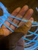 Hand holding cool white EL wire - Close-up of flexible electroluminescent strand showing thin wire construction for sewing into fabrics