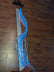 EL wire strand laid out on wooden surface - Extended view of 34-inch cool white electroluminescent wire for sewing into costumes