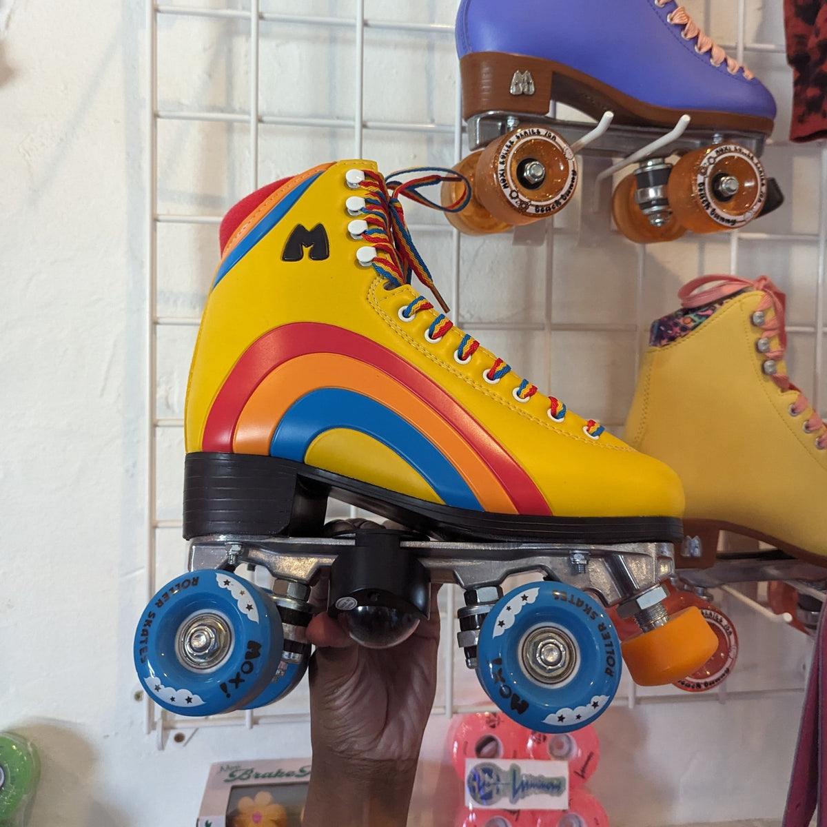Rainbow decorated roller skates with blue wheels and star projector attachments showing versatile customization options for personalized skating style