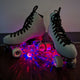 Close-up of roller skates with illuminated star projectors showing pink and red light pattern effects for enhanced skating visibility and aesthetic appeal