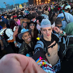 light up neon cowboy hat on festival goer at edc rave music festival with friend and wearing candy bracelets for his selfie