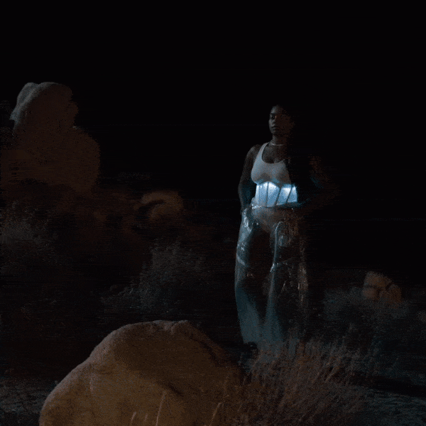 Model showing white light-up LED corset over basic tank top at night, demonstrating how programmable corset illuminates for music festivals and light-up fashion