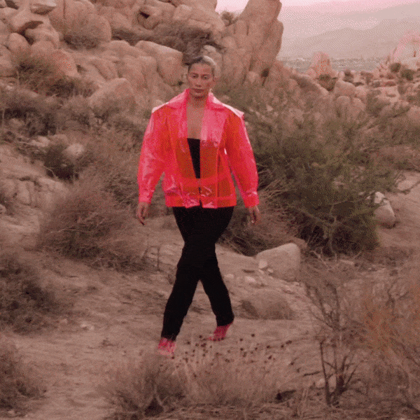 Neon hot pink LED fringe jacket in daylight showing dramatic fringe details perfect for festival fashion statement pieces and rave outfits