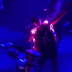 Person performing on stage in blue illuminated nudie suit creating dramatic visual effects for concert performances DJ sets and theatrical productions