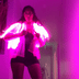 Close-up of glowing pink LED fringe jacket in dark venue demonstrating vibrant illumination for stage performances clubs and nighttime events