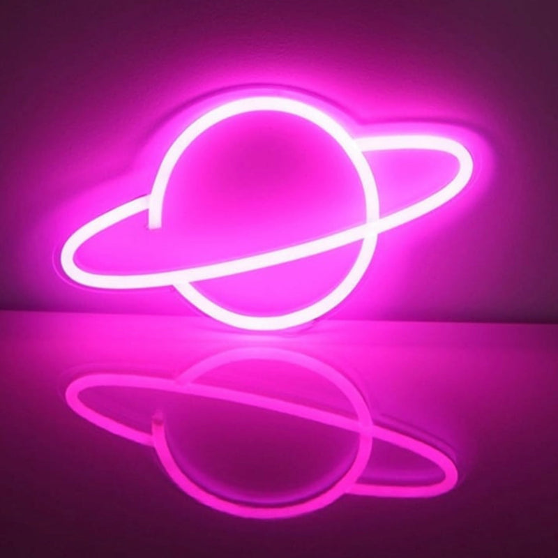 A pink glowing Saturn LED neon sign shaped like a ringed planet mounted on a wall with a soft reflection, a cosmic space-themed planet neon sign and glow room decor, perfect for bedrooms, dorms, gaming setups, and celestial party backdrops, Neon Cowboys planet neon sign, Neon Cowboys